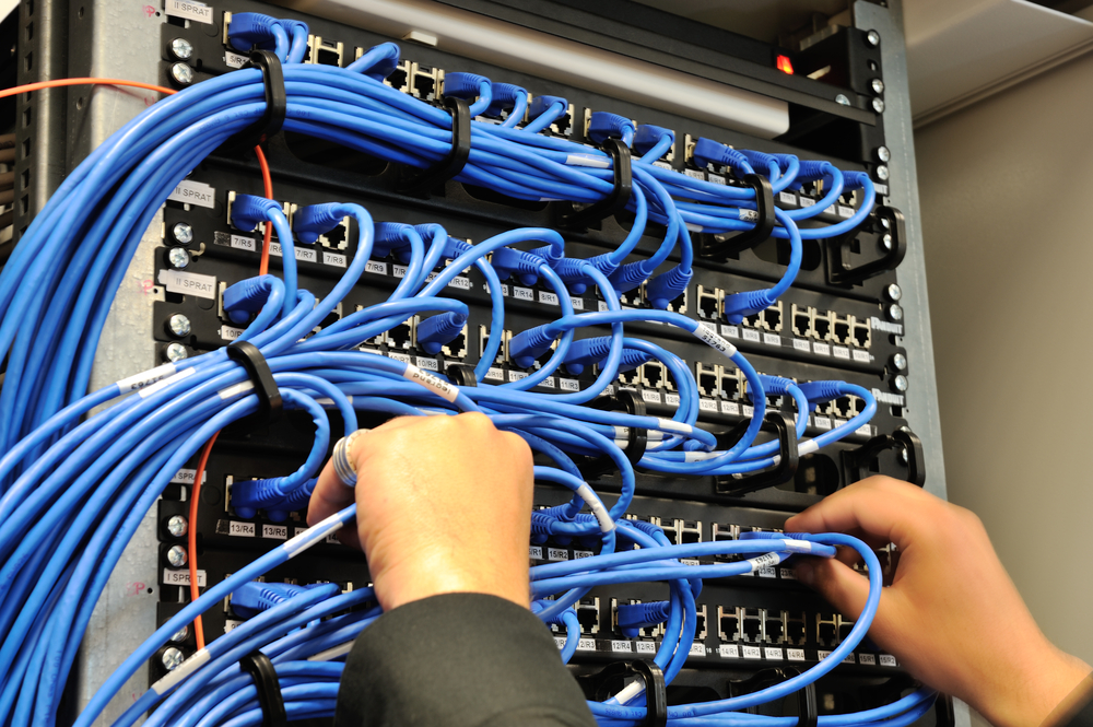 Man connecting it network cables to switches